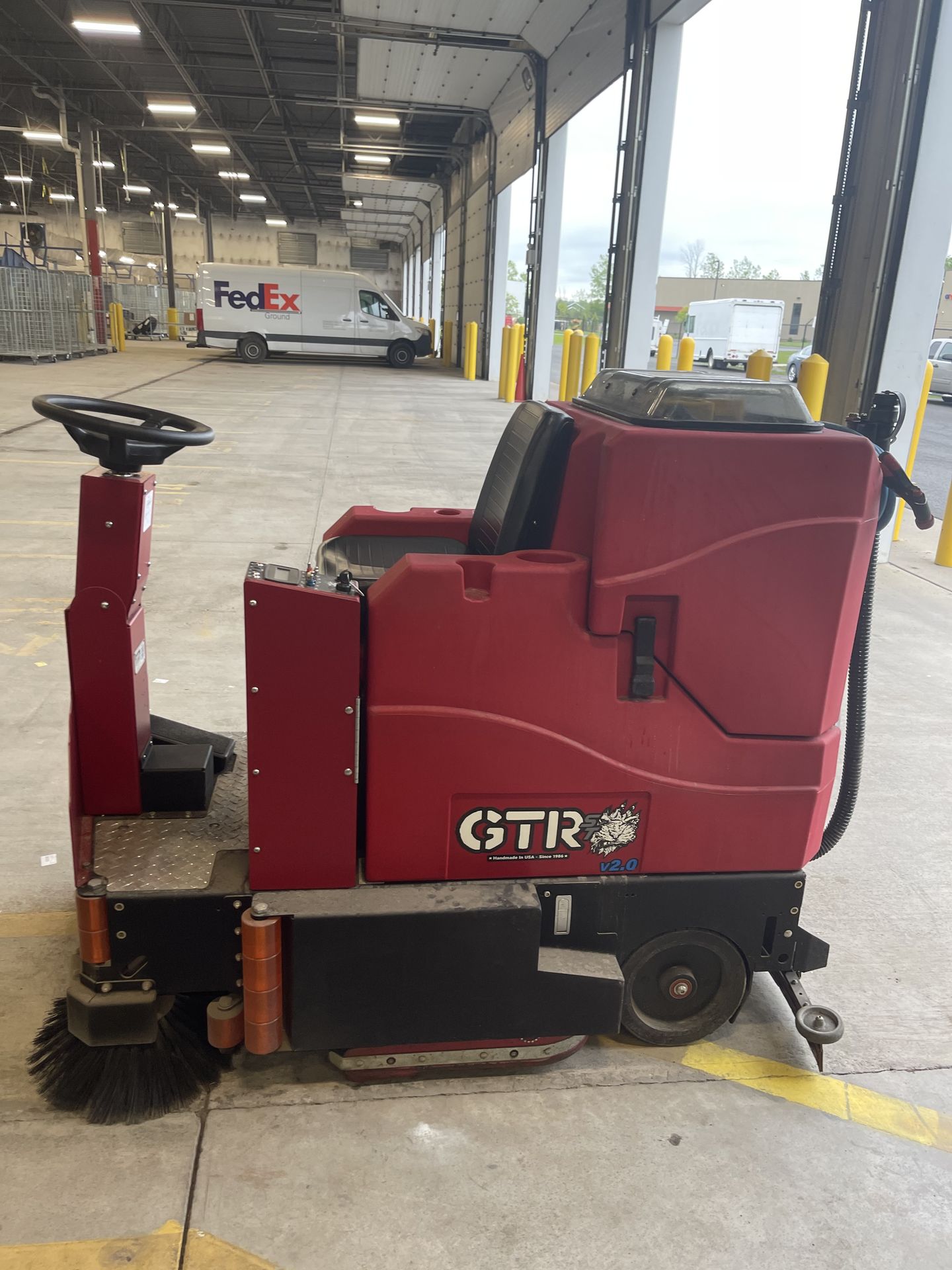 Ride-on floor scrubber cleaning a commercial loading dock facility